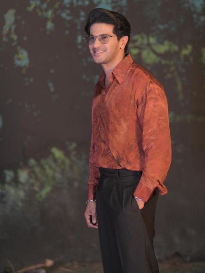 A wider shot of Dulquer's promotional look. The relaxed fit of the shirt gives it a comfortable, easygoing vibe.