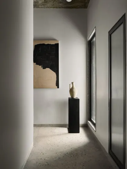This corridor in Pavilion House acts as a tranquil transition space. The minimalist design, with its monochrome palette and focus on light and shadow, creates a meditative journey through the home, connecting the public and private wings.