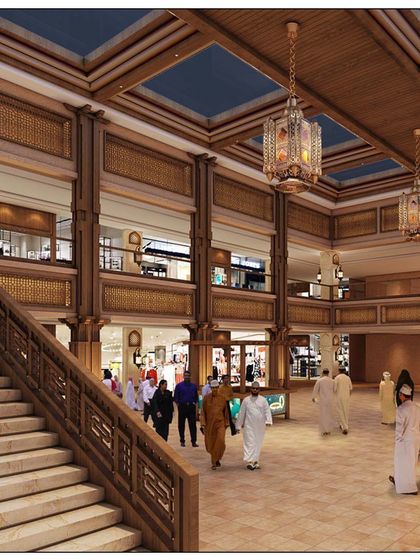 The interior of Souq al Madina, showing the multi-level retail space. The design features Omani stone, traditional wooden latticework (mashrabiya), and large skylights to create an authentic and pleasant shopping experience.
