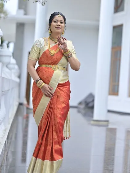 Amulya radiates elegance in this luxurious bridal silk saree, featuring a striking contrast of deep red and off-white.