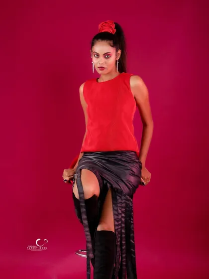 A strong pose that showcases the thigh-high slit and the edgy details of the outfit.