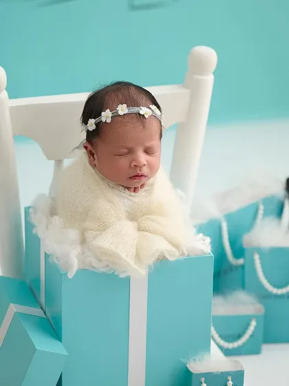A luxurious, Tiffany-inspired theme, with a newborn sleeping in a signature blue box, surrounded by pearls and gift bags.