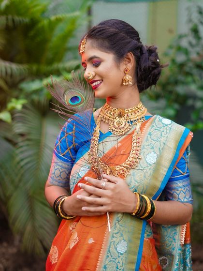 A candid-style bridal portrait capturing a moment of quiet joy. The bride's natural smile and the soft lighting against a lush green background create a beautiful and timeless image.