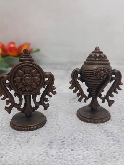 A pair of copper Shanku and Chakram idols, the divine symbols of Lord Vishnu. These are essential for any Vaishnavite shrine.