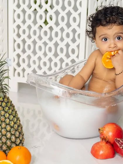 A healthy snack and a warm bath all in one. This little one is enjoying our fruit splash session, a fun and unique way to capture playful toddler moments.