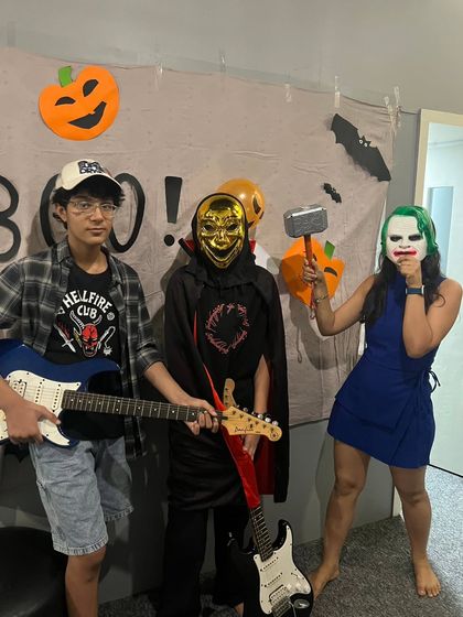 Ready to rock this Halloween! Students and a teacher pose with their guitars and costumes, bringing some fun character energy to the jam room.