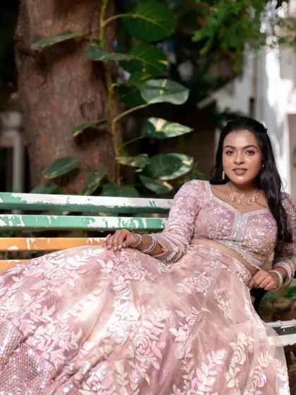 A model sitting on a colorful bench, showcasing a modern and subtle reception look.