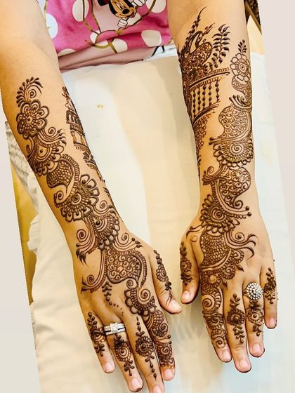 A flowing, full-arm Arabic design. This style is characterized by its bold lines, floral and paisley motifs, and the way it elegantly covers the hands and arms.