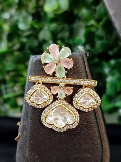 The matching earring for this set, featuring a delicate floral design.