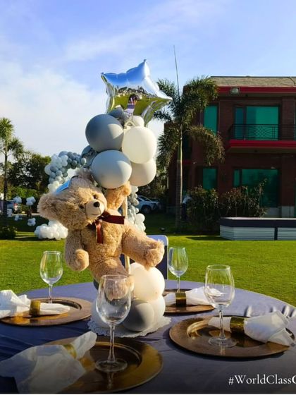 A whimsical and luxurious table setting for a special celebration. The teddy bear centerpiece and balloons show our ability to cater to themed events, like birthdays or baby showers, with a touch of class.