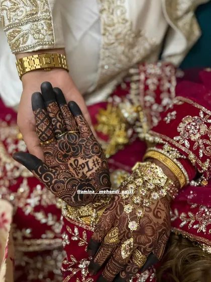 It's so special to see the final look come together. Here, the groom holds the bride's hand, showcasing the beautiful henna as part of their wedding story.