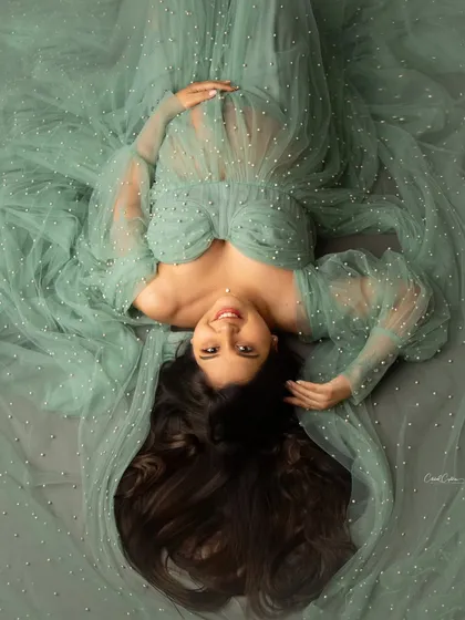 A unique perspective can create a truly memorable image. This artistic overhead shot captures the mom-to-be lying peacefully, enveloped by her beautiful mint green gown. It’s a serene and creative take on a maternity portrait.