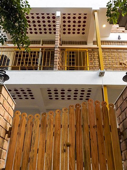 The proportion of the wooden gate to the brick pillars creates a welcoming and well-scaled entrance.