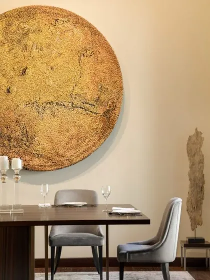 A closer look at the dining space, where the large circular artwork creates a powerful focal point. The simple, elegant furniture and soft lighting ensure that the focus remains on art, food, and conversation.