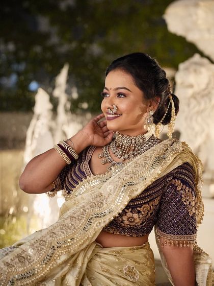 A candid moment showing the bride's smile. Her hair is styled in a classic bun with delicate accessories, a perfect choice for a timeless bridal look.