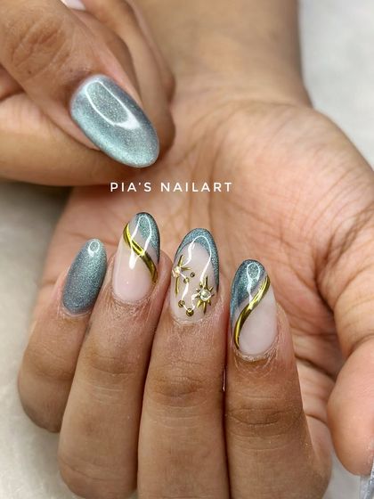 The cat eye trend is here to stay. This set uses a grey-green magnetic polish with gold chrome lines and star accents for a celestial vibe.