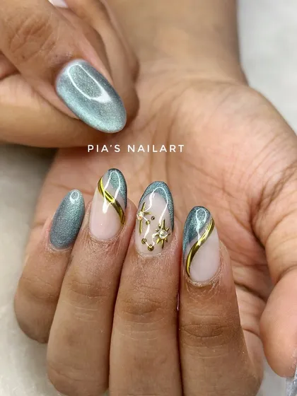 The cat eye trend is here to stay. This set uses a grey-green magnetic polish with gold chrome lines and star accents for a celestial vibe.