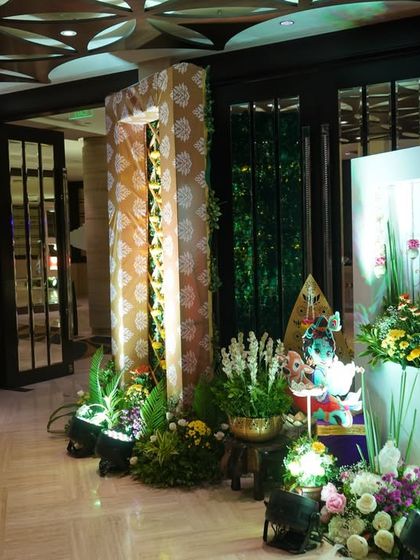 The entrance to the Krishna-themed baby shower. The walkway is lined with traditional Indian decor elements and floral arrangements, creating a culturally rich and welcoming passage for guests.