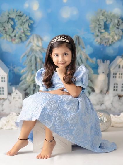 A little girl dressed as Princess Elsa in a magical winter wonderland. This theme is a favorite for Christmas and holiday mini sessions.