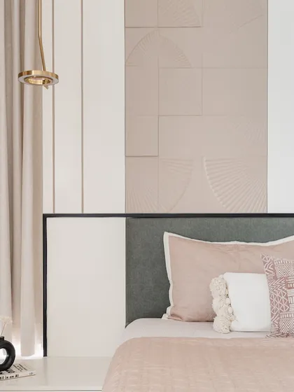 Soft pastel pinks and a textured fan-patterned wall create a gentle and modern bedroom. The design focuses on subtle textures and a calm color scheme to craft a restful and stylish space.