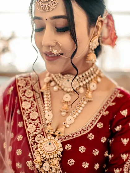 A close-up of the bride, showing the delicate details of her makeup. The soft, smoky eye and perfectly defined lips create a look of timeless beauty.