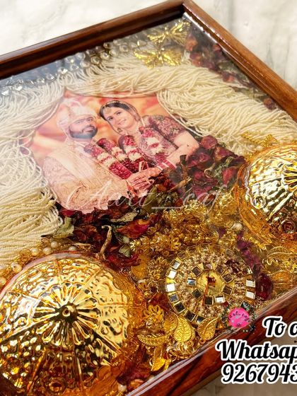 This frame beautifully preserves the groom's sehra alongside the varmala and kaleera. The delicate white threads of the sehra create a stunning curtain-like effect around the couple's photo.