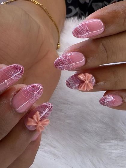 Soft, sweet, and full of texture. This design features a glittery pink base with delicate white line work and cute, sculpted 3D bows in a matching peach-pink shade.