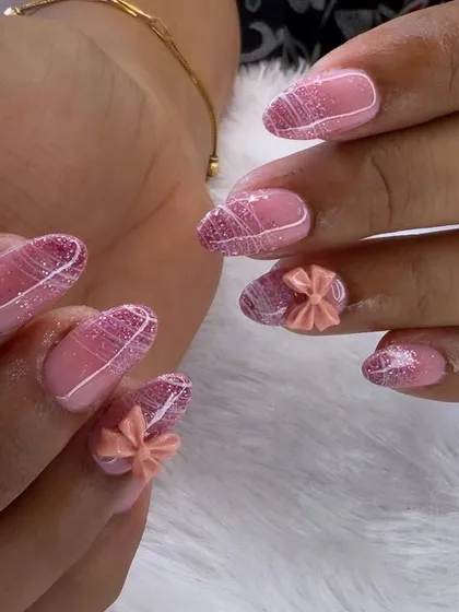 Soft, sweet, and full of texture. This design features a glittery pink base with delicate white line work and cute, sculpted 3D bows in a matching peach-pink shade.