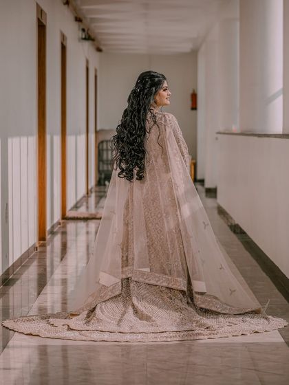 A back-shot of a bride showing off the beautiful trail of her gown and her long, flowing hair.