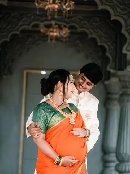 A beautiful couple's portrait from a traditional maternity photoshoot. The rich colors of the saree and the elegant architectural backdrop add a touch of royal grace to these precious memories.