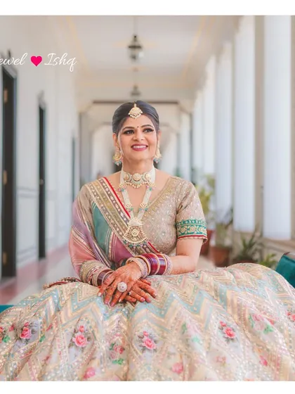 The bride seated, her magnificent lehenga spread out, perfectly complemented by the custom jewellery I designed for her.