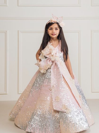 This ombre sequin gown fades from pink to silver, adorned with 3D floral details for a truly unique look.