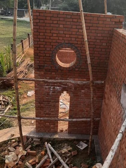 Every opening in the Ashadeep School was carefully considered. The circular and arched windows are not just for light and air; they are playful 'eyes' that frame views of the surrounding village and create a connection to the world outside.