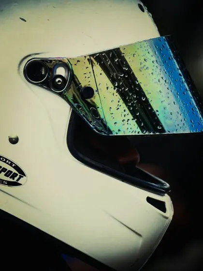 A close-up of a helmet visor with raindrops.