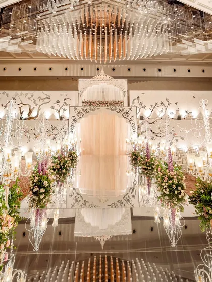 The grand reveal of our double-decker entrance structure for a reception. With performers on the upper level and a dramatic curtain drop, the couple made their entrance through a mirrored archway, surrounded by intricate floral arrangements and elegant lighting.