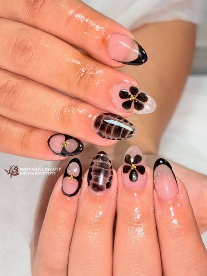 A closer look at the elegant black floral nail art, showing the precision and creativity involved in hand-painted designs.