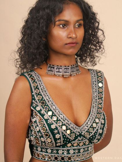 An angled close-up of the green mirror work blouse, providing another view of the detailed embroidery and the garment's structure.