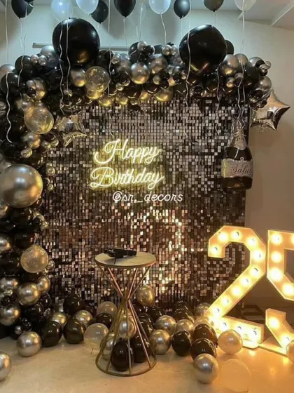 Celebrate a milestone 25th birthday in style with this sophisticated black and silver theme. A shimmering sequin wall, a modern neon sign, and large light-up marquee numbers create a high-energy, club-like atmosphere.