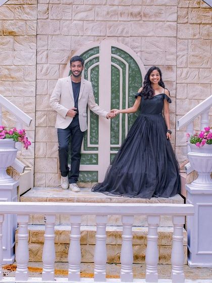 A couple on a grand white staircase, a perfect setting for an elegant and classic pre-wedding photo.