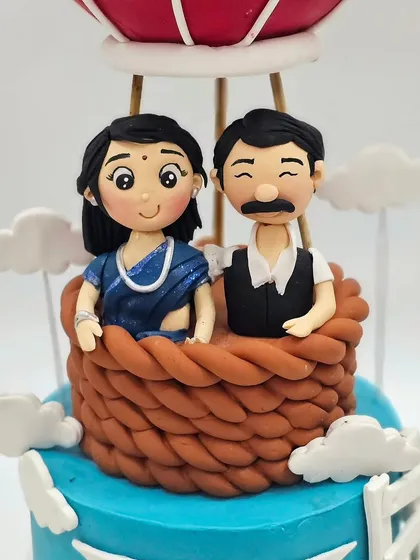A close-up of the hand-sculpted couple figurines, capturing their likeness in a charming, cartoonish style.