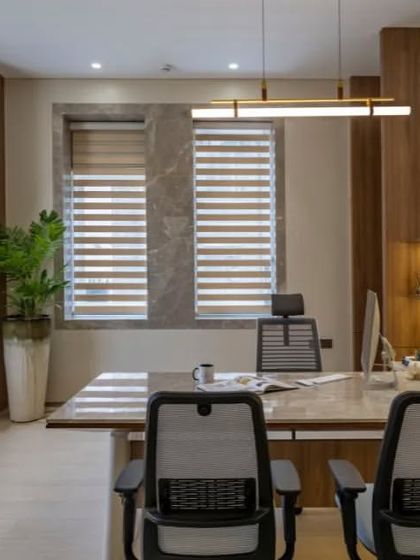 Natural light is a key element in this executive office. Large windows with adjustable blinds allow for control over the lighting, creating a bright and energizing workspace.