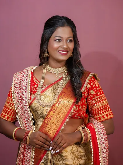 The complete look, with a focus on how the rich colors of the saree and the gold jewelry complement her skin tone.