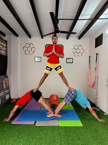 Three person downward dog pyramid. This acro yoga pose is a fun way to build strength and work as a team.