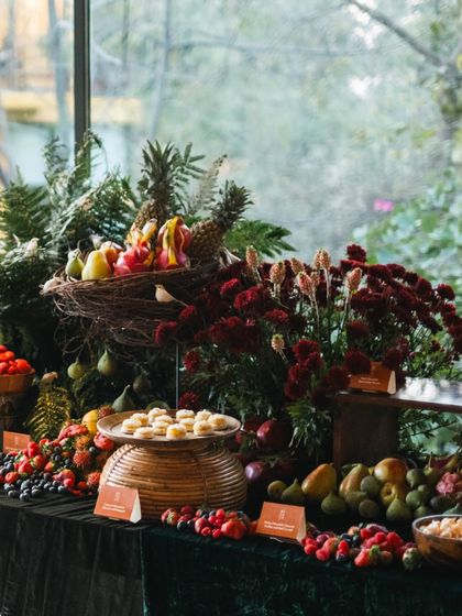 A cornucopia of fresh fruit, including pineapples, figs, and berries, forms a stunning centerpiece on this grazing table. The arrangement highlights our commitment to fresh, seasonal produce.