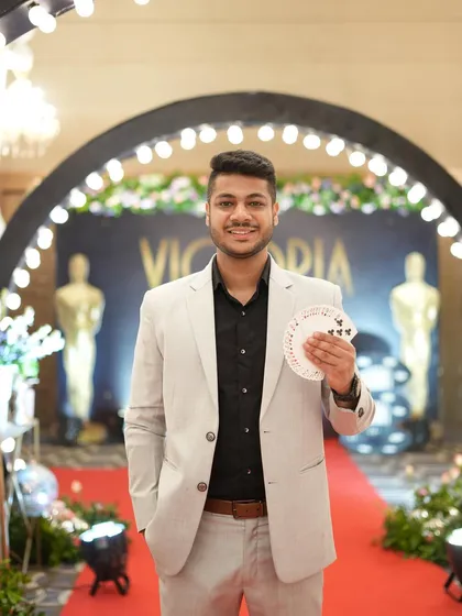 Holding a fan of cards on the red carpet before my performance for the Government of India's AGM. The stage is set for a night of wonder.