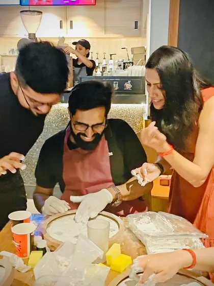 Teamwork makes the dream work. Colleagues helping each other get the texture just right for their moon lamps during a corporate team-building event.
