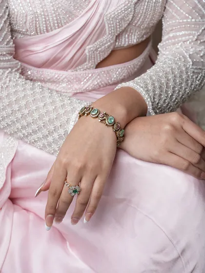 A close-up of the Navratan bracelet and ring, kissed with soft pastels and vibrant gemstones, perfect for festive occasions.