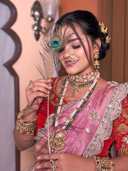 Another beautiful portrait with the peacock feather, highlighting the bride's serene expression and flawless makeup.