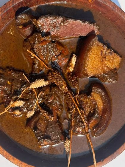 Another view of the Smoked Pork Anishi, garnished with wild herbs. This dish is a true taste of the Ao Naga tribe's culinary heritage.