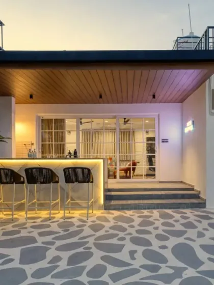 For Villa 17, we transformed the rooftop into a Santorini-inspired escape. This multipurpose space includes an outdoor bar with custom lighting and patterned Kota stone flooring, creating a functional and beautiful area for relaxation and entertainment.